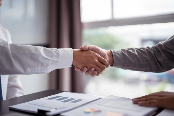 Business professionals shaking hands after signing a deal