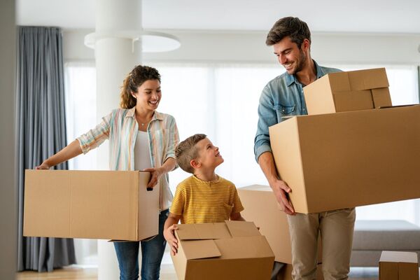 Happy family with a young child moving into their new home